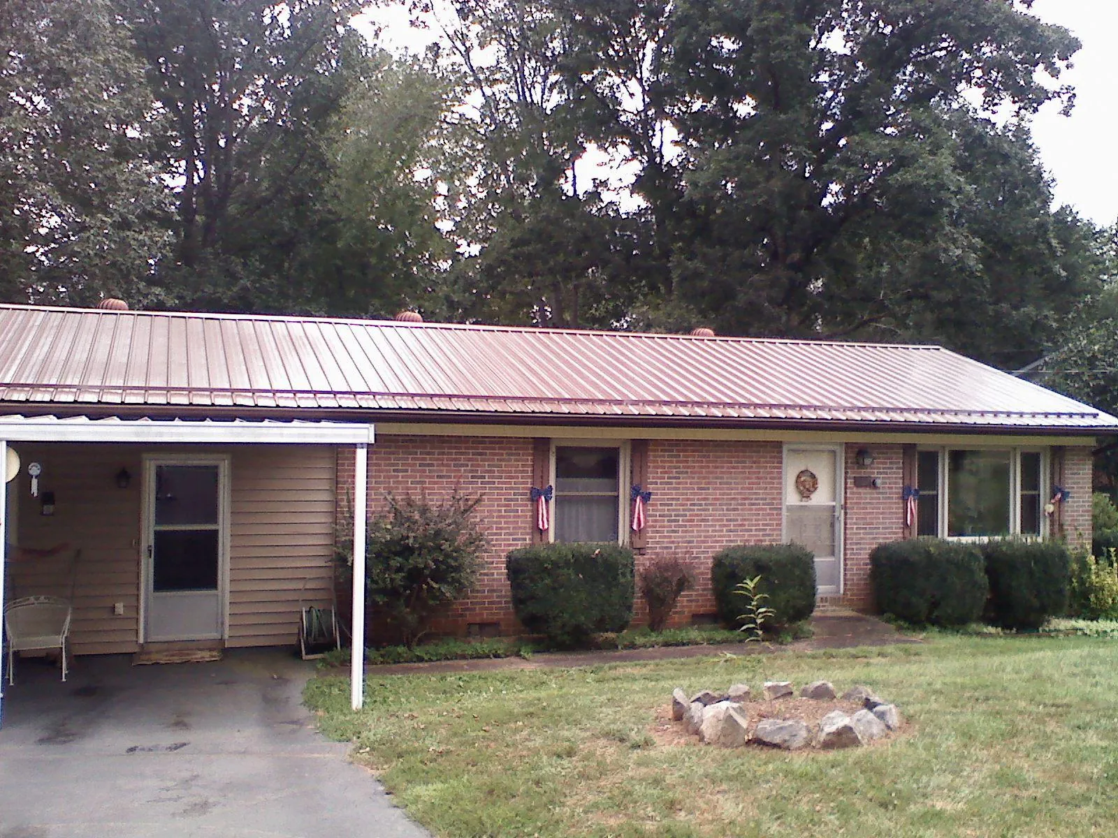 Bronze metal roof and carport on a brick ranch home — Roof Repair work by our crew in Vanleer